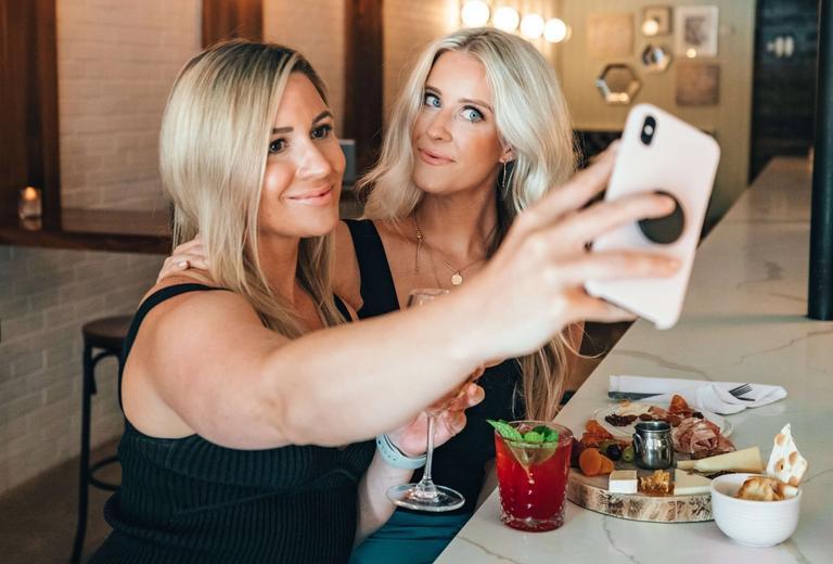 two girls taking a selfie at a nice bar