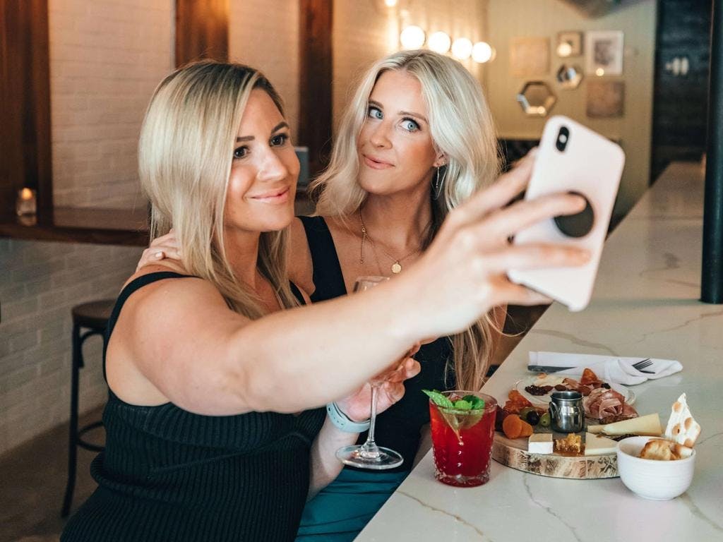 two girls taking a selfie at a nice bar
