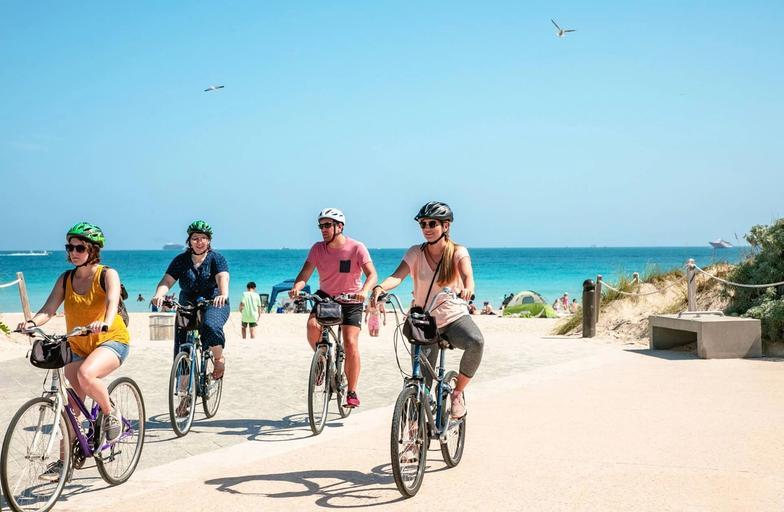 A family biking near the beach coast