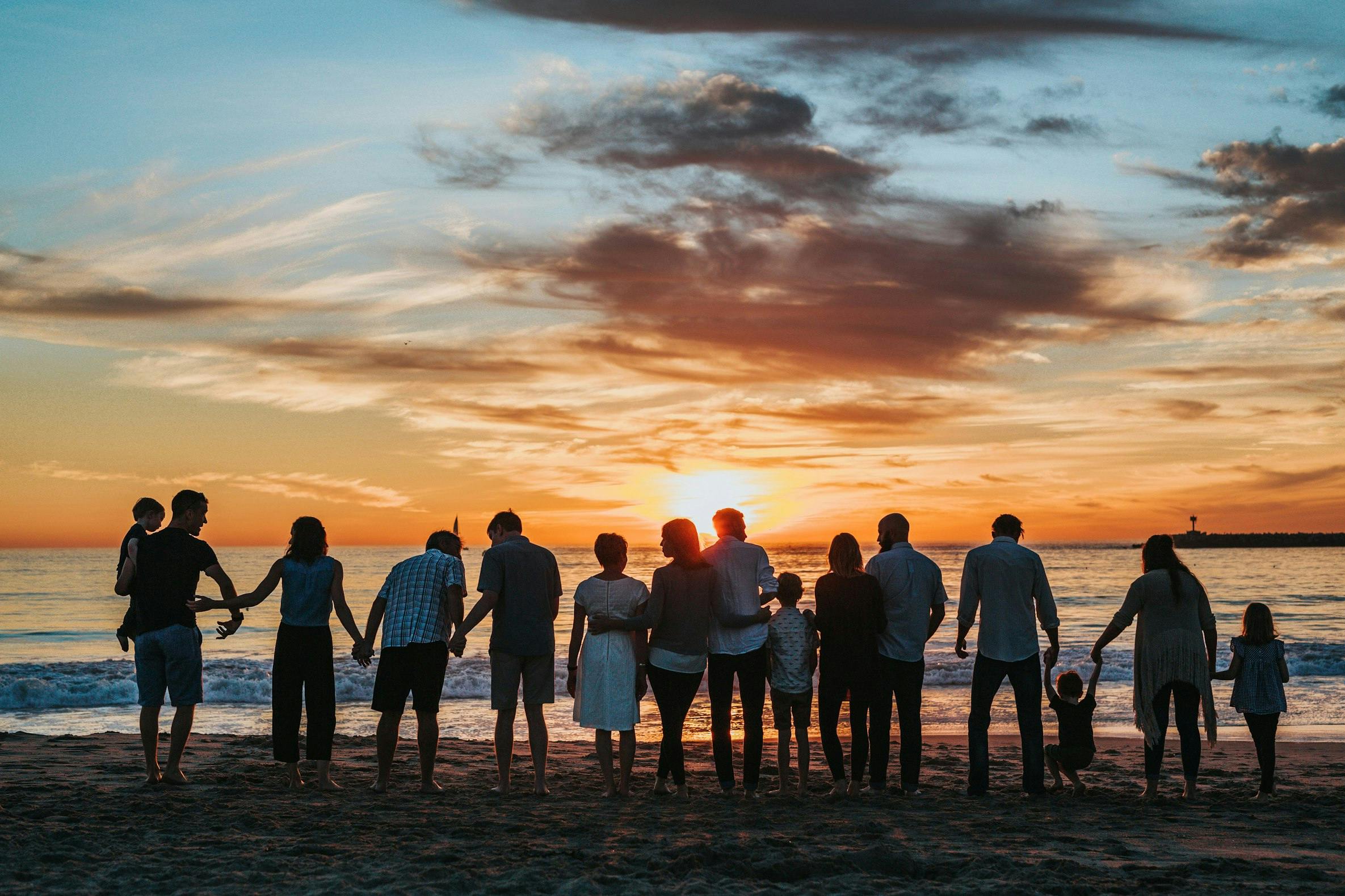 Family holding hands on the beach in the sunset